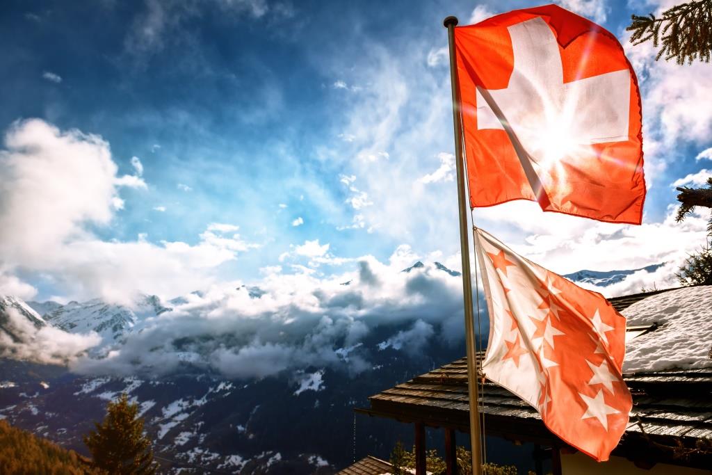 曇天のスイスアルプスとスイス国旗